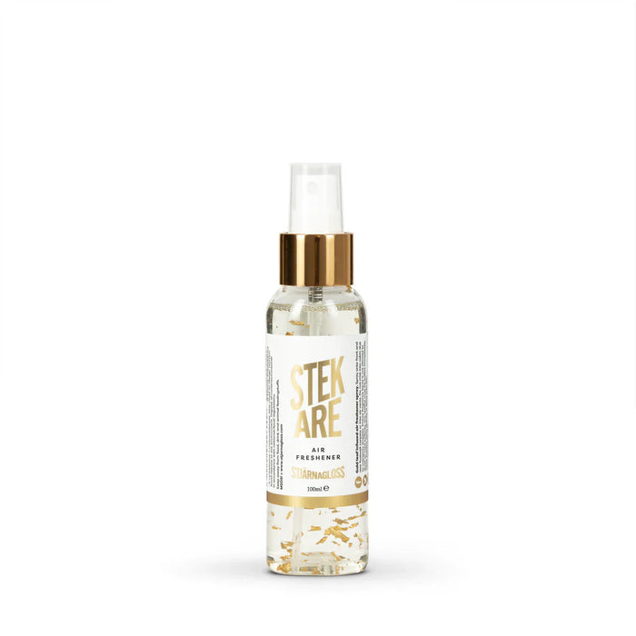 Stjarnagloss Spray bottle with gold cap and white label on a white background